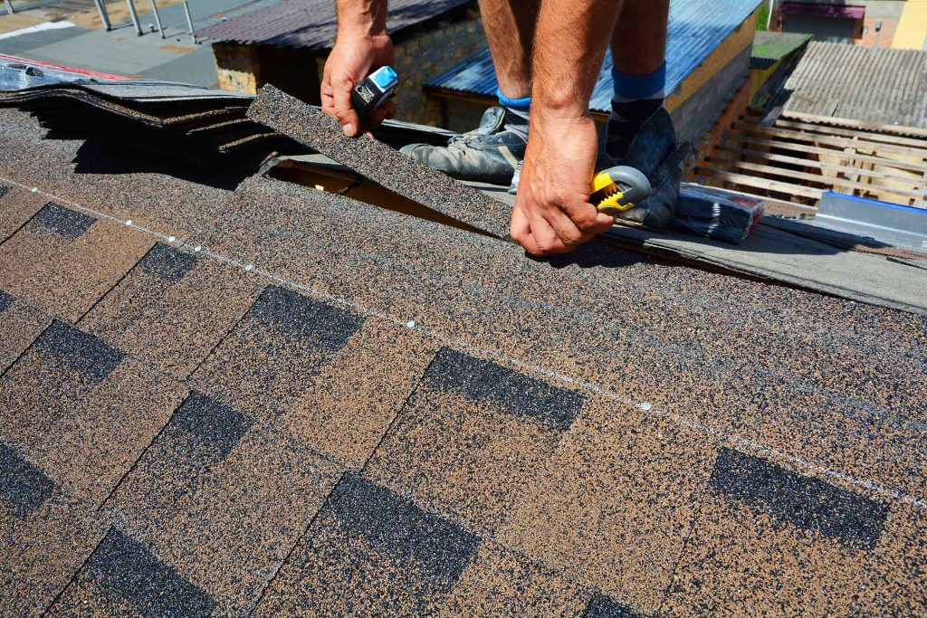 Skilled roofer 'installing shingles' with precision on a residential roof